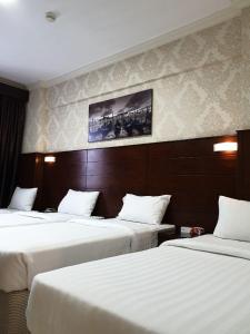 a hotel room with two beds with white sheets at Mirage Al Salam Hotel in Medina +43 photos