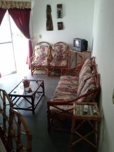a living room with a couch and chairs and a table at Recanto do descanso in Iguaba Grande