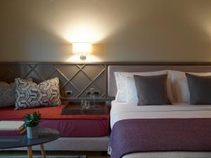 a hotel room with a bed and two lamps at The Lake Hotel in Ioannina