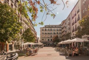 マドリードにあるExplore Madrid from a warm apartment with patio at a newly refurbished manorial buildingの表と椅子と建物のある街道