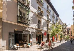 マドリードにあるExplore Madrid from a warm apartment with patio at a newly refurbished manorial buildingの建物前の通りを歩く女