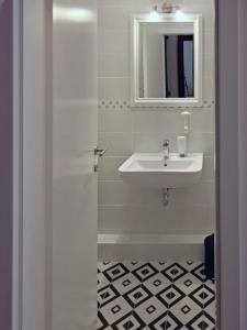 a white bathroom with a sink and a mirror at Sedaki Apartments in the Center of Zagreb in Zagreb
