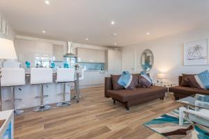 a living room with a couch and a kitchen at Treetops Apartment in Milton Keynes