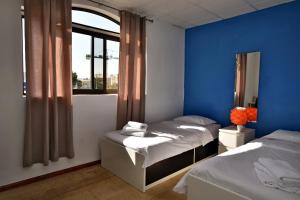 a bedroom with two beds and a blue wall at City Living Suite TK2 Rm 1 in St Julian's