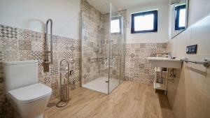 a bathroom with a shower and a toilet and a sink at Apartamentos Rurales Argame in Argamé +183 photos