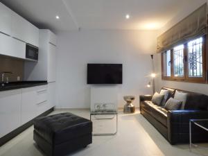 sala de estar con sofá y TV en Polo Apartments - Benahavís en Benahavís