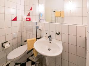 a white bathroom with a sink and a toilet at Hotel Löwen Garni - B&B in Rust