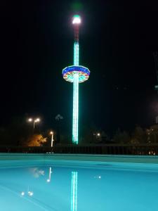 una ruota panoramica illuminata di notte con piscina di Hotel Vittoria a Pesaro