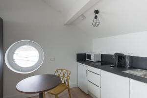 a kitchen with a table and a round window at Le Jardin d Ambroise in Saint-Priest-en-Jarez