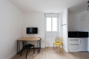 a small kitchen with a table and chairs in a room at Le Jardin d Ambroise in Saint-Priest-en-Jarez