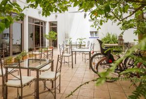 un patio con mesas, sillas y una bicicleta en Hotel Alcántara, en Sevilla