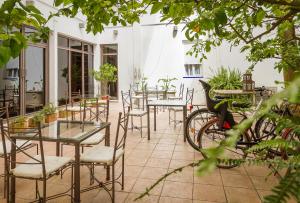 a patio with tables and chairs and a bike at Hotel Alcántara in Seville