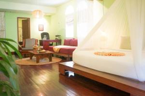 a bedroom with a bed and a living room at iRoHa Garden Hotel & Resort in Phnom Penh