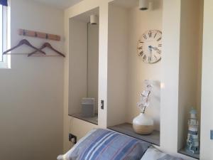 ウェイマスにあるSelf-contained small apt. Weymouthのベッドルーム1室(壁に時計、ベッド1台付)