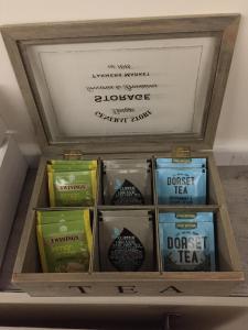 una caja de madera llena de diferentes tipos de té en Self-contained small apt. Weymouth, en Weymouth