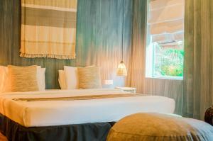 a bedroom with a large bed with a window at iRoHa Garden Hotel & Resort in Phnom Penh
