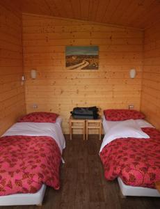 2 Betten in einem Zimmer mit Holzwänden in der Unterkunft Agri Village in Certosa di Pavia