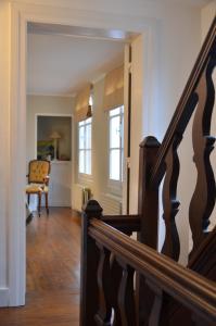 a hallway with a staircase and a chair in a house at Le Petit Maur in Spa