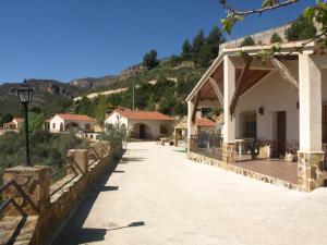 a walkway next to a building with a mountain at El Tejo Yeste y Mirador del Segura in Yeste