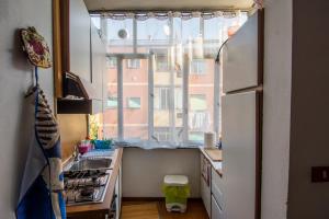 una cucina con frigorifero bianco e finestra di DA PINA a Milano