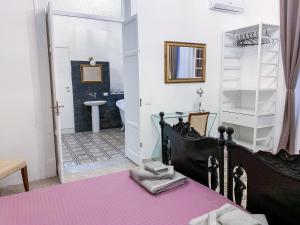 a bedroom with a bed and a bathroom at Liberty Suites in Palermo