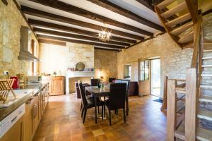 a kitchen with a table and chairs in a room at Au coeur de Beynac, superbe maison du 16ème siècle avec jardin panoramique in Beynac-et-Cazenac