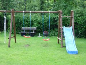 a playground with three swings in a yard at Finken, Gästezimmer an der Rench in Oppenau