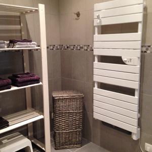 a bathroom with a shower with white organizers at Maison Chabrat in Liginiac