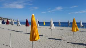 una fila de sombrillas en una playa con el océano en Hotel Doria, en Varazze