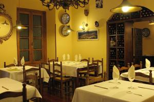 a restaurant with tables and chairs with white tablecloths at Hostal Esmeralda in Comillas