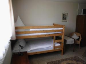 a bedroom with two bunk beds and a chair at Finken, Gästezimmer an der Rench in Oppenau