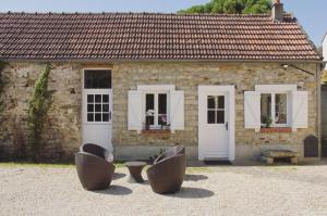 a stone house with a couch in front of it at Corps de ferme restauré proche Barbizon in Saint-Martin-en-Bière