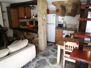 a kitchen with a white refrigerator and a table in a room at Cozy Xisto in Mata