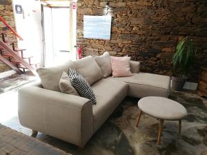 a couch in a room with a brick wall at Cozy Xisto in Mata