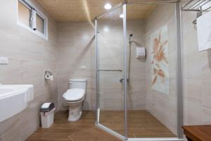 a bathroom with a shower and a toilet and a sink at Happiness B&B in Linbian