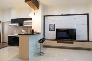 uma cozinha com uma grande televisão e um banco num quarto em Happiness B&B em Linbian