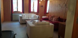 a living room with two chairs and a couch at Chalet Spillstatt in Grindelwald