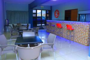 un ristorante con tavoli e sedie e un muro di mattoni di Angel Guest House a Johannesburg