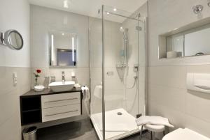 a bathroom with a glass shower and a sink at Hotel Spiegel in Cologne