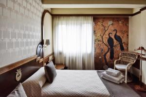 a bedroom with a bed and a chair and a window at Hotel Maria Luisa in Burgos