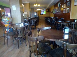 jadalnia ze stołami i krzesłami w restauracji w obiekcie Pensión Sol e Mar w mieście O Pindo +25 zdjęć