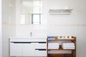 un bagno con lavandino, specchio e asciugamani di 5+1 Homestay a Magong