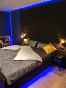 modern Hoteliving Gießen في أوليمبياذا: غرفة نوم مع سرير كبير مع أضواء زرقاء