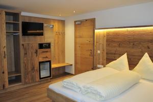una camera da letto con un grande letto e una televisione di Pension Michael a Saalbach Hinterglemm