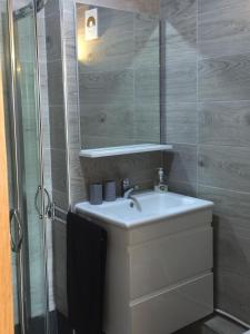 een badkamer met een wastafel en een douche met een spiegel bij Marina Golf Asilah GEHEEL VERNIEUWD EN GERENOVEERD in Asilah