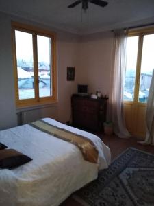 1 dormitorio con 1 cama grande y 2 ventanas en bed and breakfast " La Terrazza", en Génova