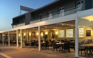 a restaurant with tables and chairs in front of a building at Le Cannier Hotel in La Seyne-sur-Mer