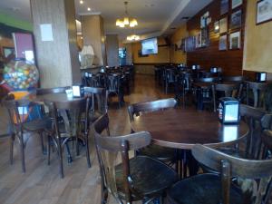 restauracja z drewnianymi stołami i krzesłami w pokoju w obiekcie Pensión Sol e Mar w mieście O Pindo