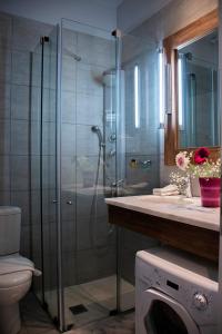 a bathroom with a shower and a washing machine at Alissachni Luxury Apartments in Derveni