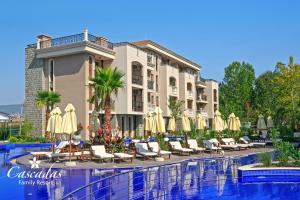 a hotel with chairs and umbrellas next to a pool at Cascadas Family Resort in Sunny Beach